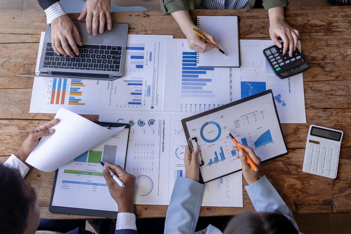 Équipe analysant des graphiques et documents autour d’une table